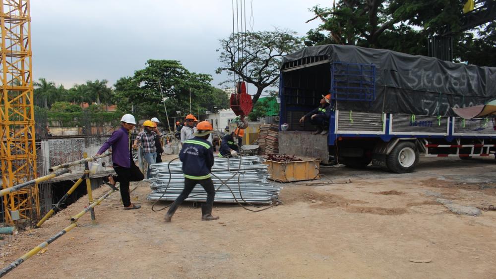 Xe chở vật liệu xây dựng ra vào nhộn nhịp trước cổng dự án